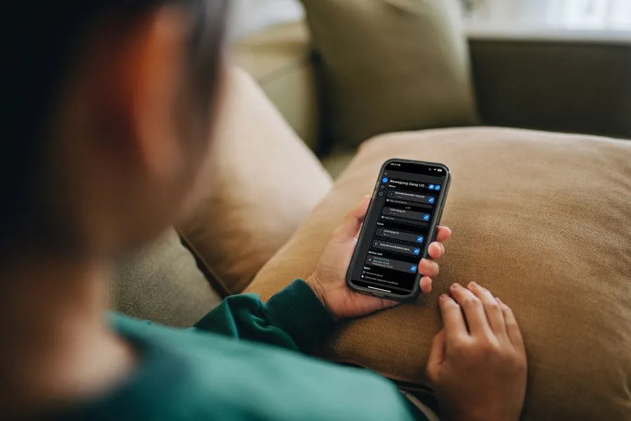 man on a sofa with the Shelly app; automations for lights, heating and security functions are based on presence.