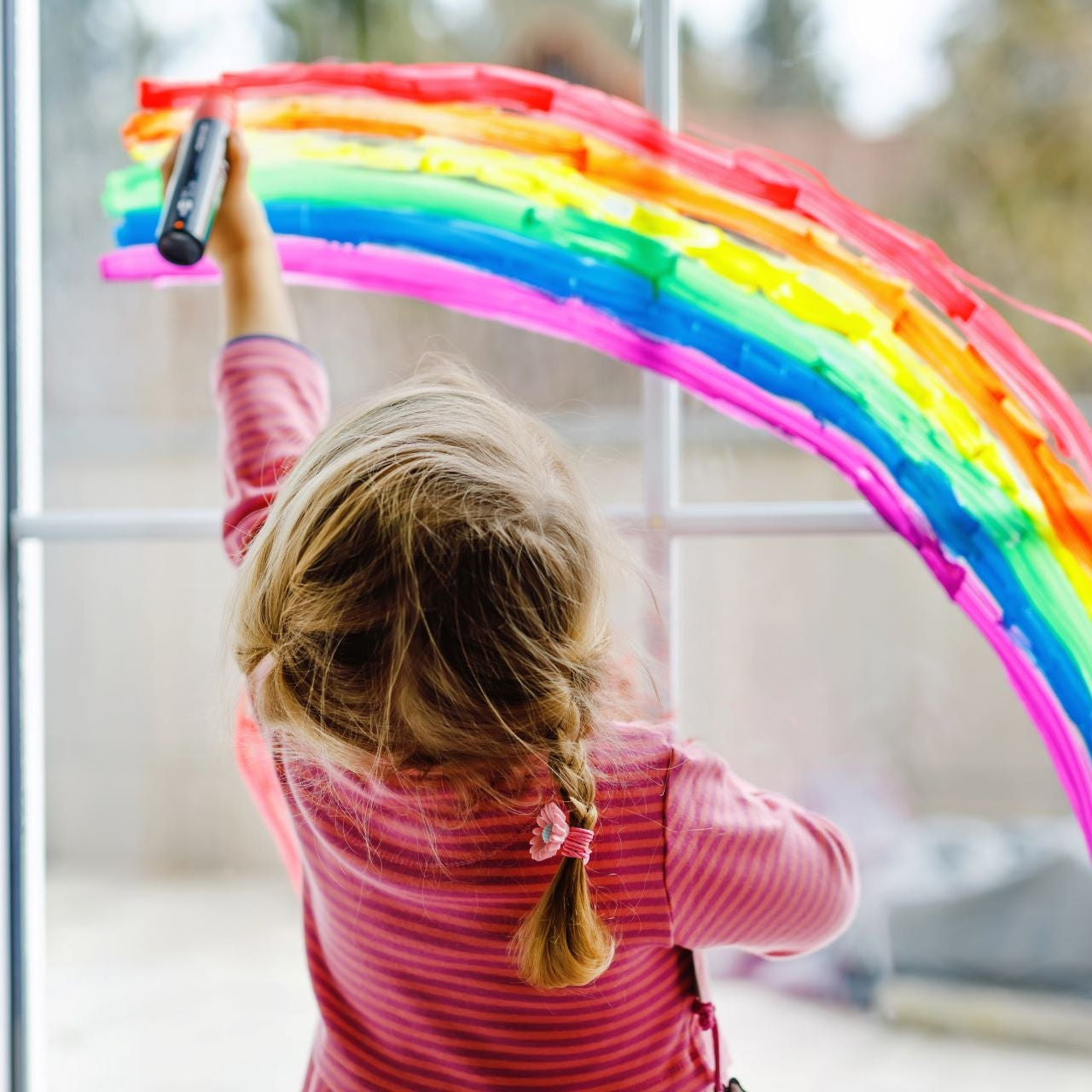 child draws a rainbow on the window; optimal indoor air protects the airways and prevents mold growth