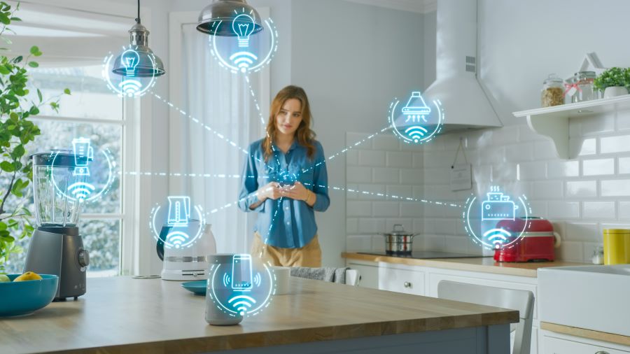 open‑plan kitchen with icons; woman in the kitchen with smartphone, controlling compatible devices in a mesh network via Z‑Wave