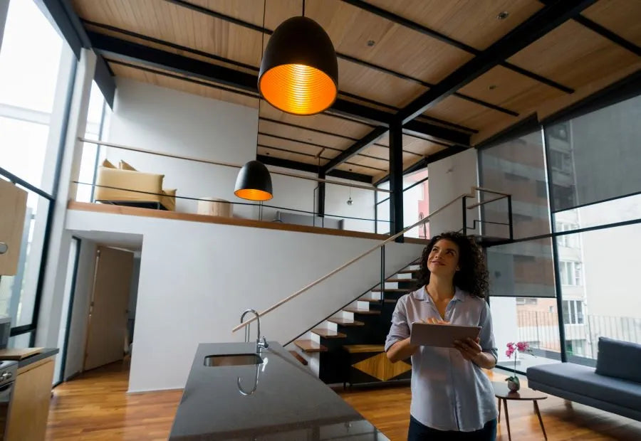 Colored ceiling light in a high kitchen‑living space; light color and brightness automated via the smart‑home app