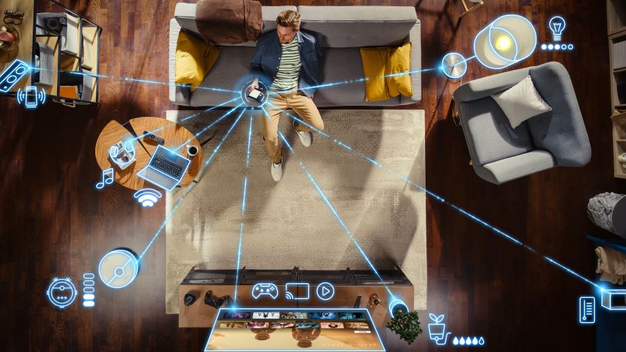 man on a couch with smartphone; blue icons visualize radio technology and devices in the smart‑home network